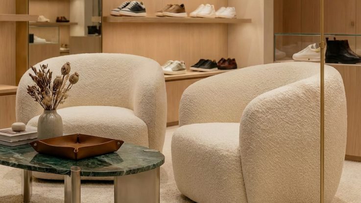 Buklet kumaş kaplı tasarım koltuk ve mat pirinç lambader yakın