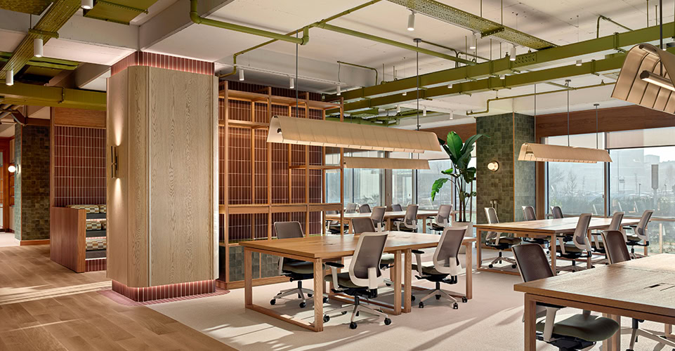 Endüstriyel tavan tasarımlı ve ahşap detaylı açık ofis çalışma alanı